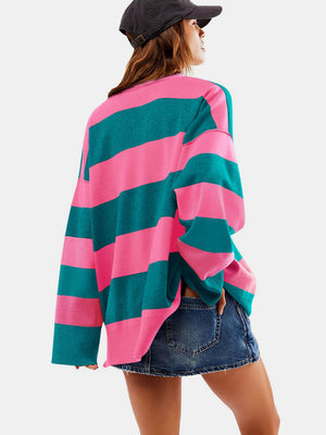 Oversized acrylic pullover with bold pink and dark green stripes, crew neck, and long sleeves.