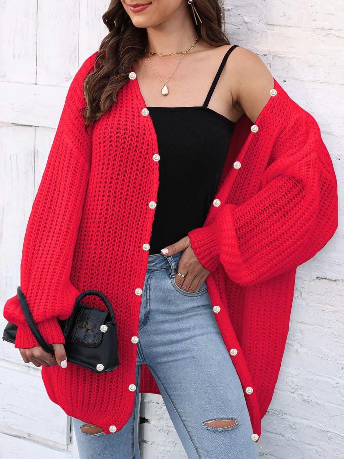 Red balloon sleeve cardigan with pearl buttons and open knit detail.
