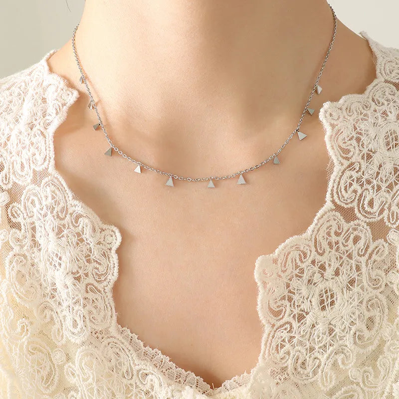 Silver necklace with dangling triangle charms on a delicate chain