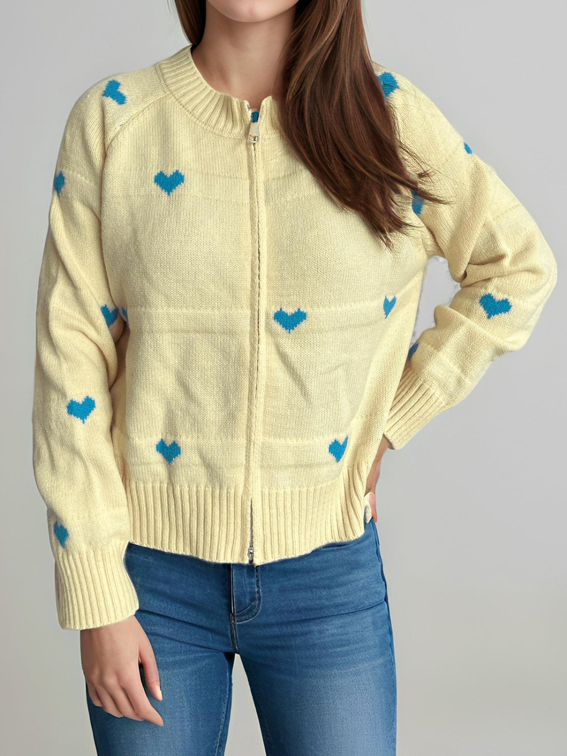 Pastel yellow zip-through knit cardigan with blue heart appliqué and ribbed cuffs.