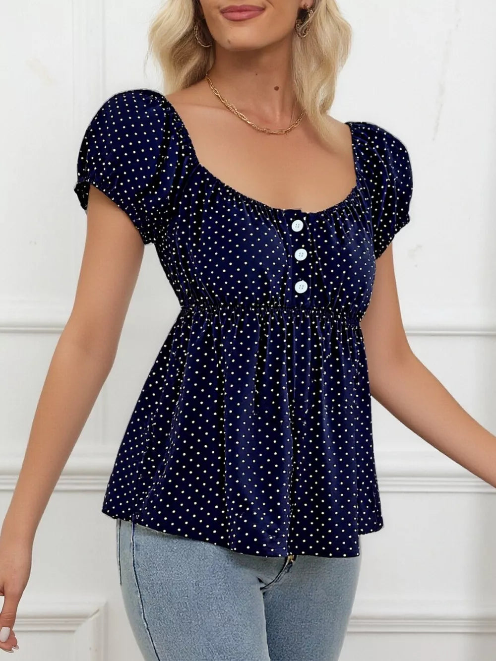 Navy polka dot shirt with puff sleeves, square neckline, and decorative buttons.