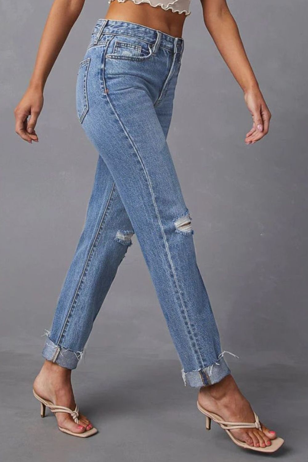 Medium wash distressed straight leg jeans with ripped knees and cuffed hems.