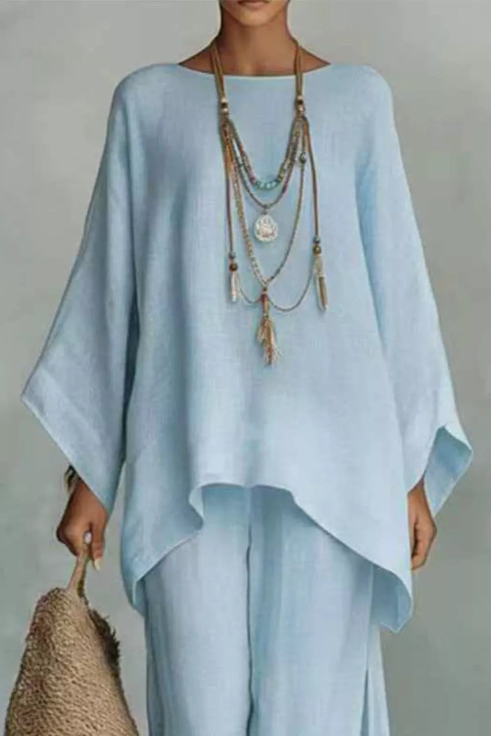 Light blue polyester two-piece set with flowing top and wide sleeves, layered necklace.
