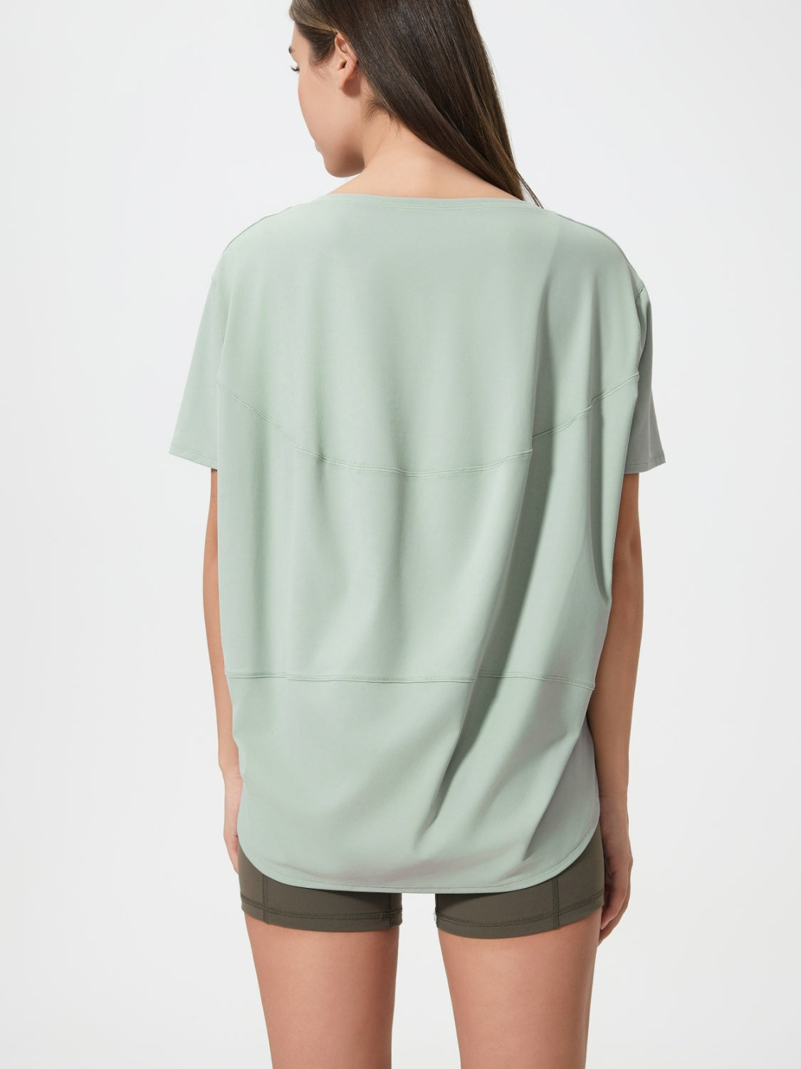 Relaxed fit performance tee in light green with curved seam details on back.