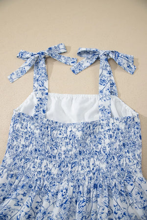 Maxi dress with blue floral print, smocked bodice, and tie-strap shoulders.