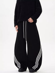 Black wide-leg sweatpants with white stripes and drawstring waist.