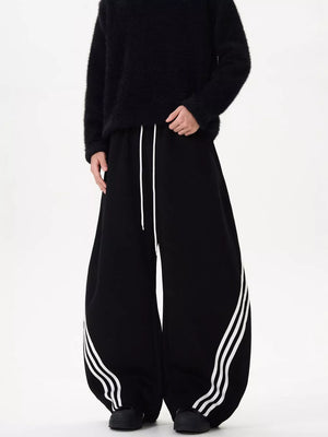 Black wide-leg sweatpants with white stripes and drawstring waist.