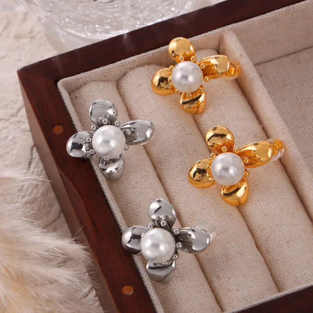 Gold and silver petal pearl stud earrings with a floral design.