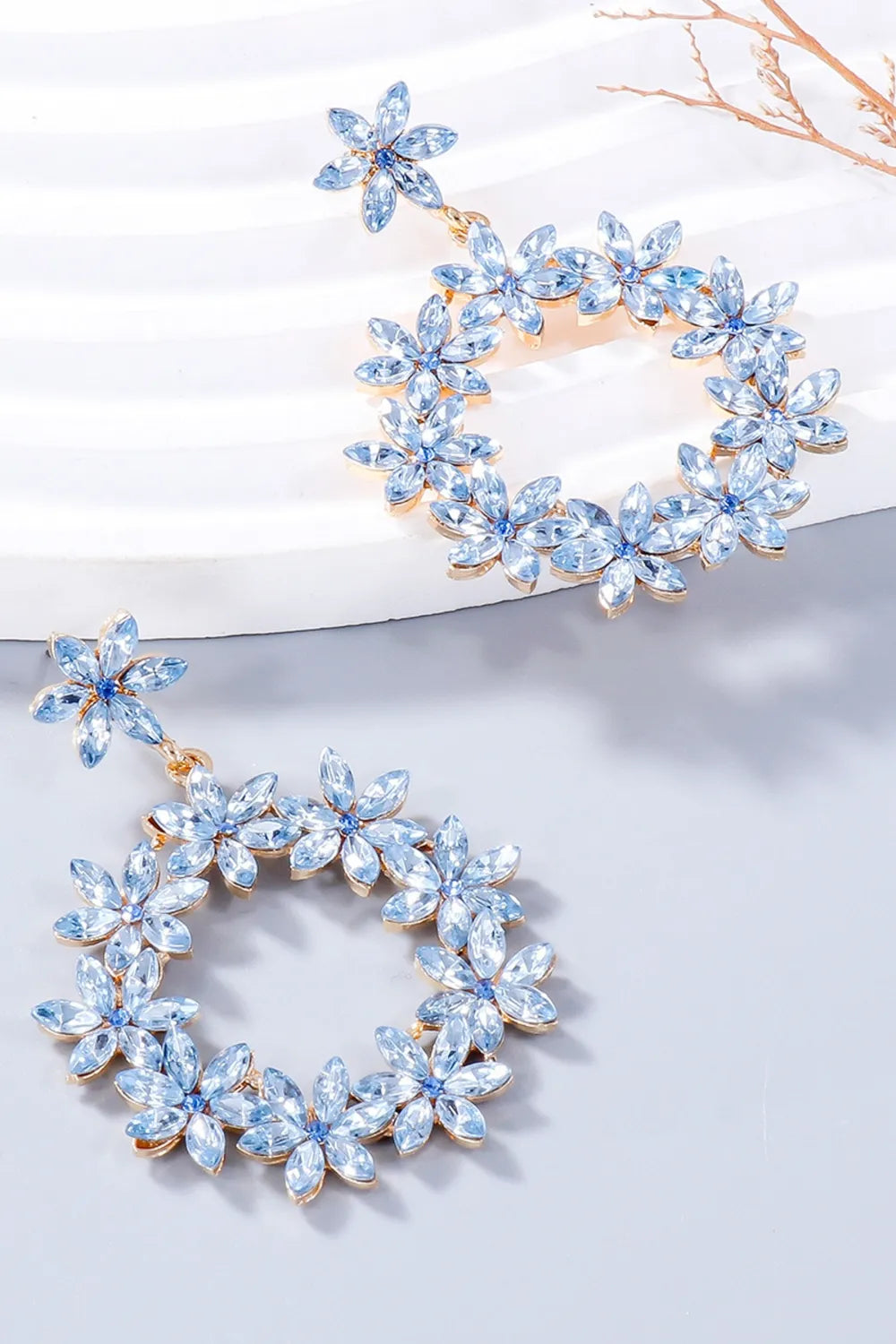 Light blue floral halo drop earrings with crystal accents and gold-tone alloy.