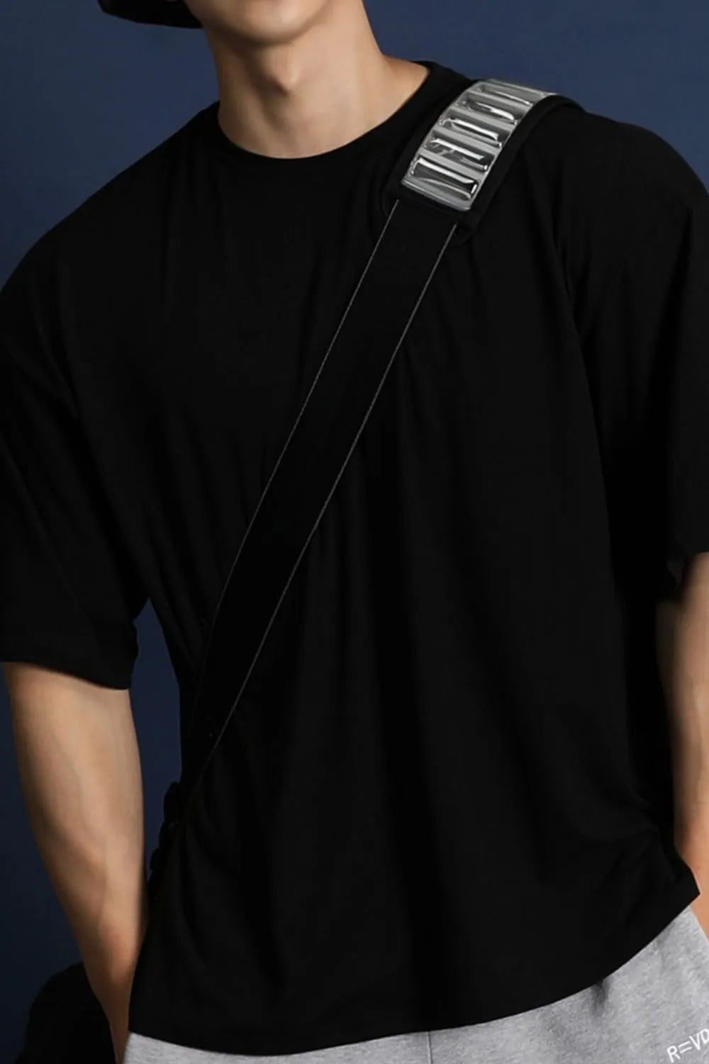 Black oversized crew neck t-shirt with a modern silhouette and silver detail on strap.