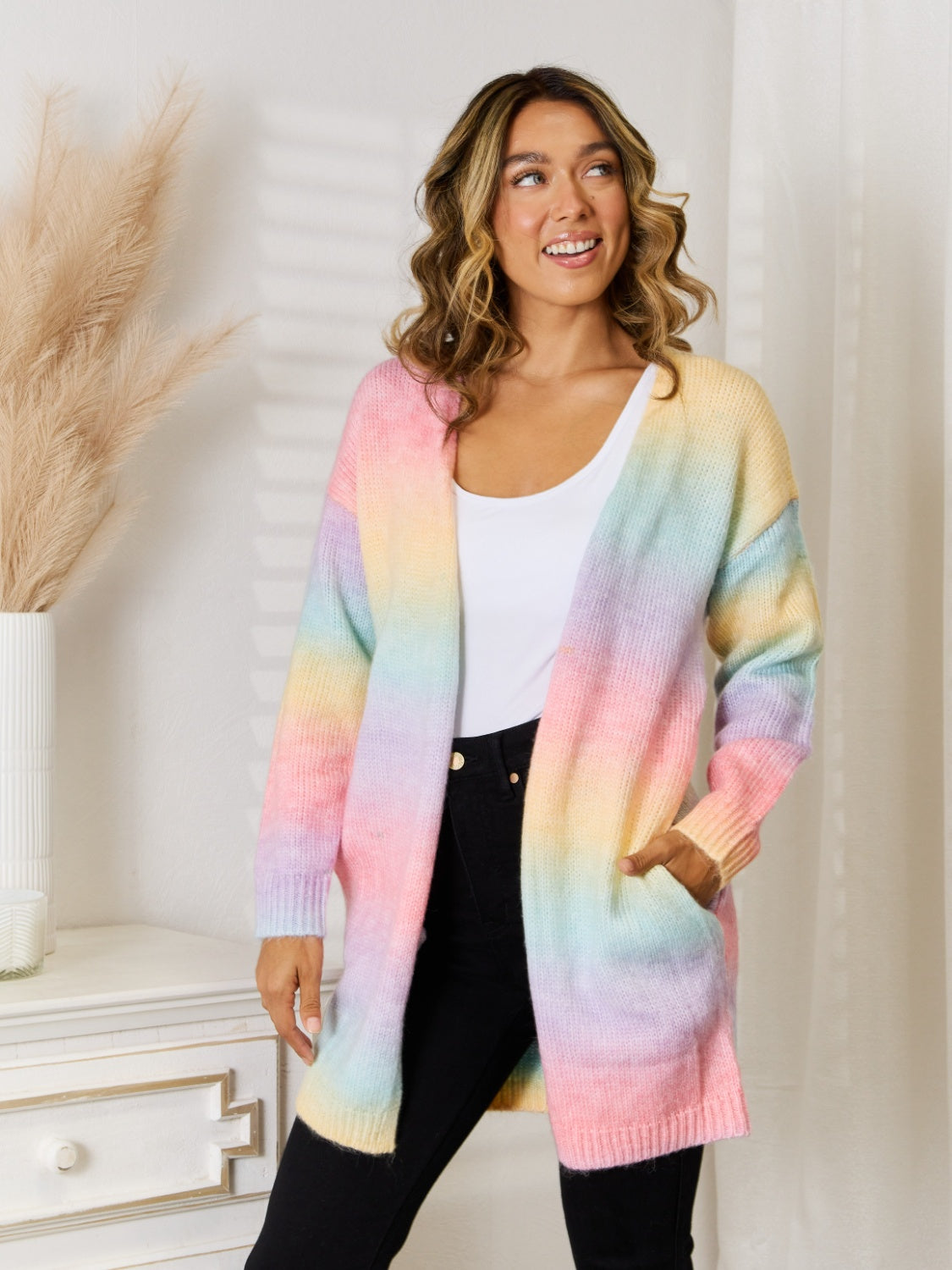 Rainbow gradient longline knit cardigan with pockets, featuring pastel pink, yellow, blue, and purple hues.