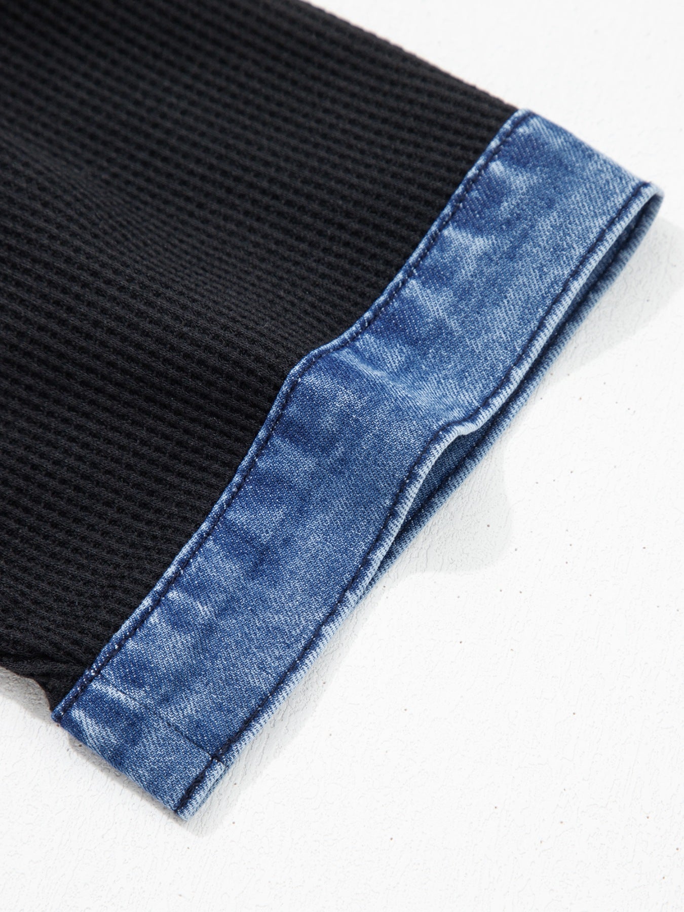 Black textured knit polo top with blue denim trim detail
