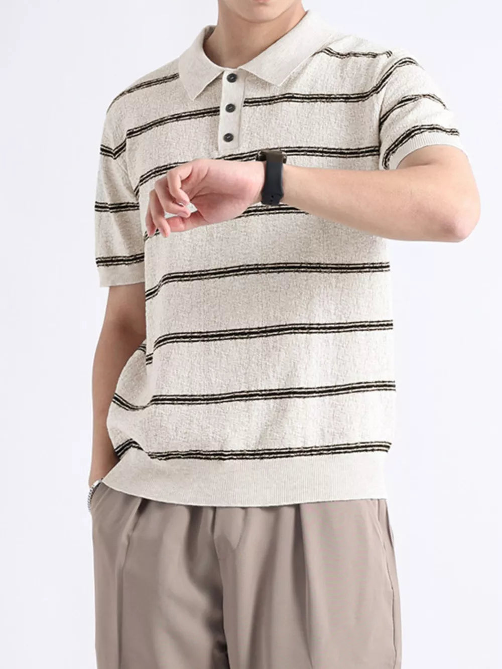 Striped knit polo shirt in off-white with black stripes, short sleeves, and button accents.