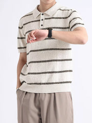 Striped knit polo shirt in off-white with black stripes, short sleeves, and button accents.