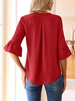Red maternity shirt with 3/4 bell sleeves, V-neck, and textured fabric.