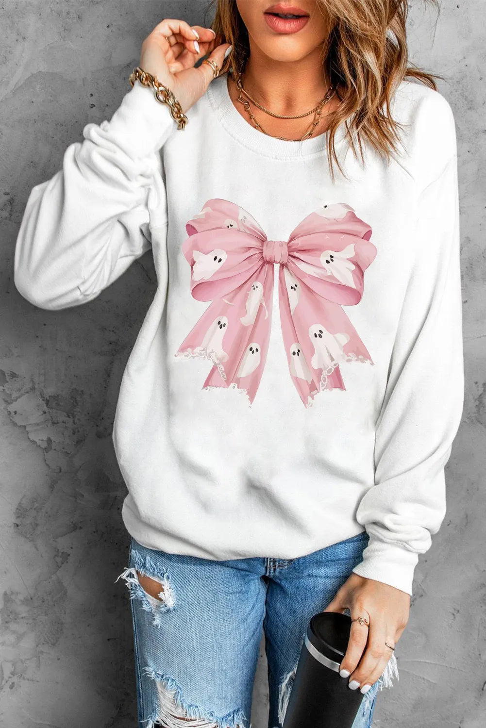 White crewneck sweatshirt with pink bow graphic featuring ghosts.