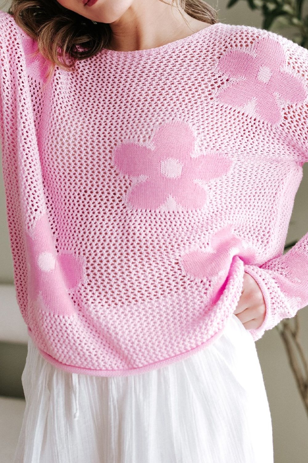 Openwork blush pink acrylic sweater with floral intarsia pattern and crew neck.