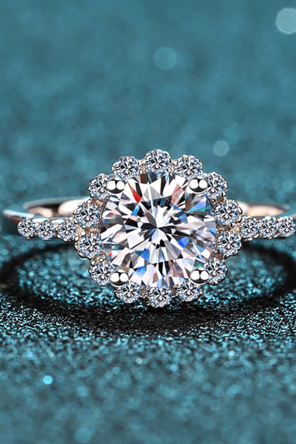 Silver halo cluster moissanite engagement ring with a round center stone and pave band.