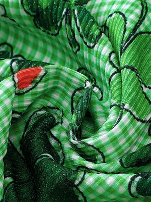 Green plaid fabric with a floral print and red accents.