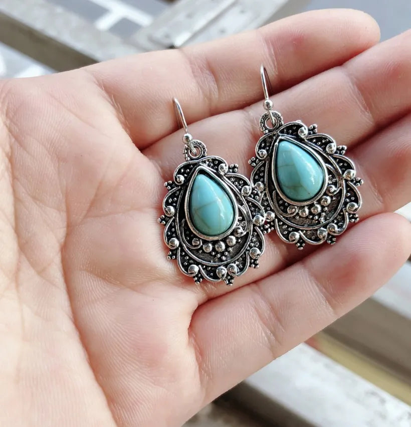 Turquoise teardrop filigree statement earrings with antique silver detailing.
