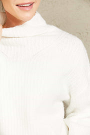 White voluminous turtleneck ribbed knit sweater with a soft texture.