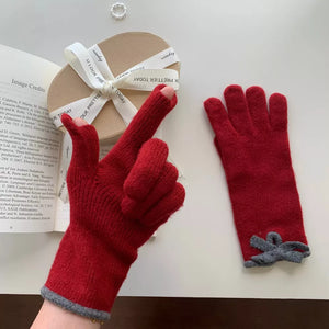 Deep Red knit gloves with grey bow detail and grey cuff, one glove has fingerless tips.