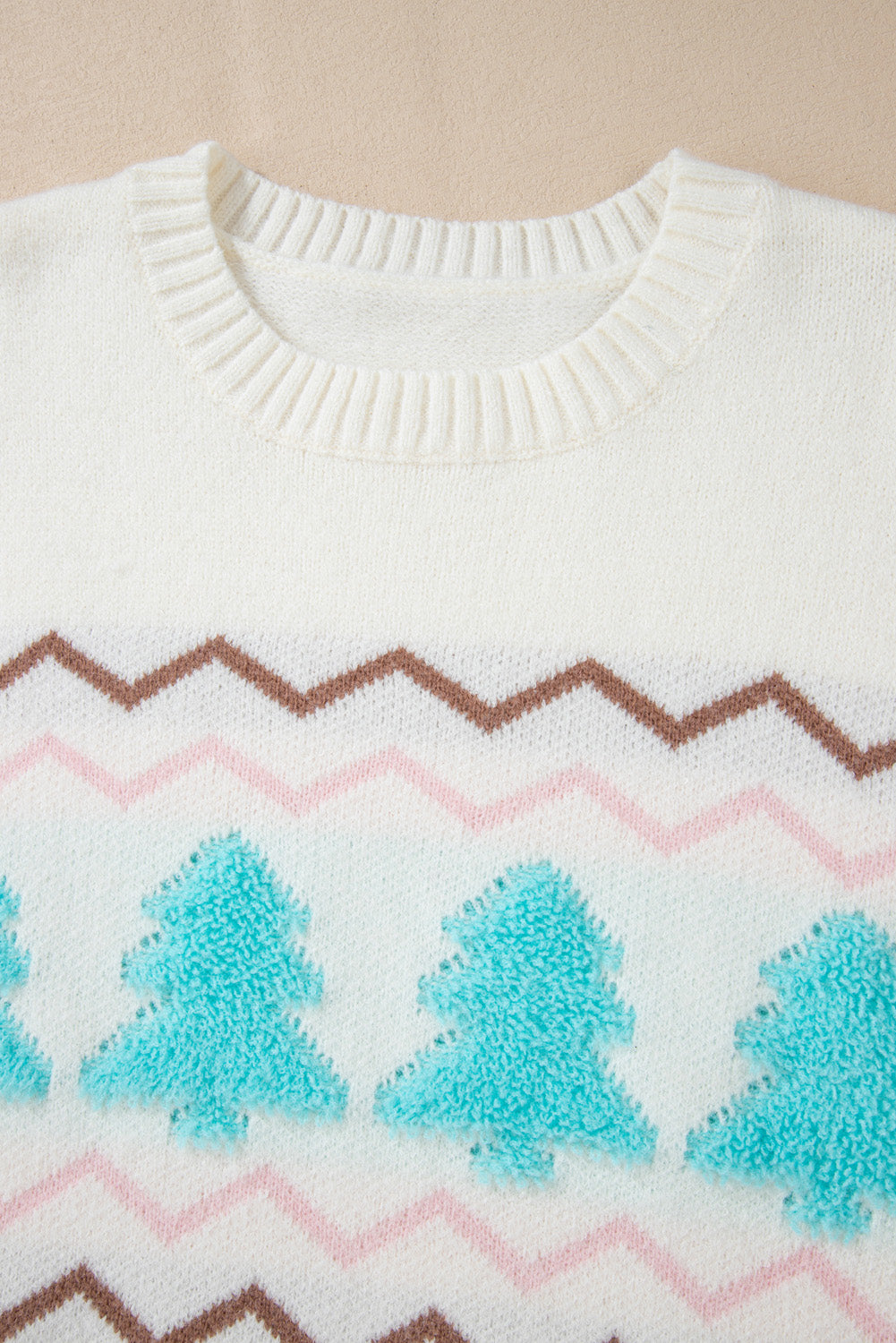 White knit sweater with textured tree motif and chevron pattern.