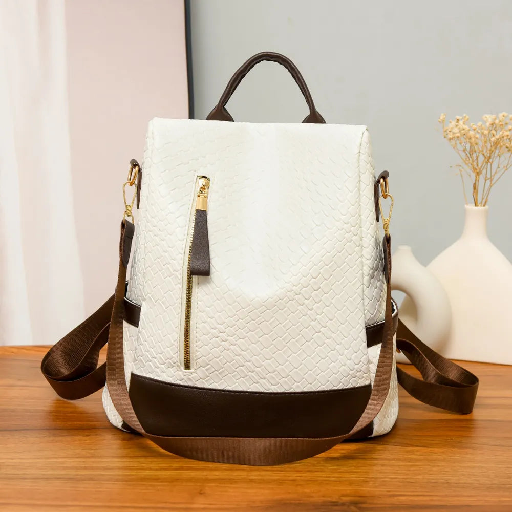 Ivory woven faux leather convertible backpack with brown trim and gold zipper.