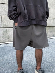 Gray relaxed fit shorts with raw hem detail.