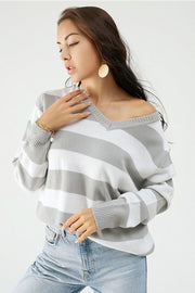 Gray and white striped V-neck relaxed knit sweater with ribbed cuffs and hem.