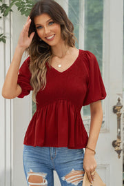 Deep Red smocked bodice peplum top with v-neck and puff sleeves.
