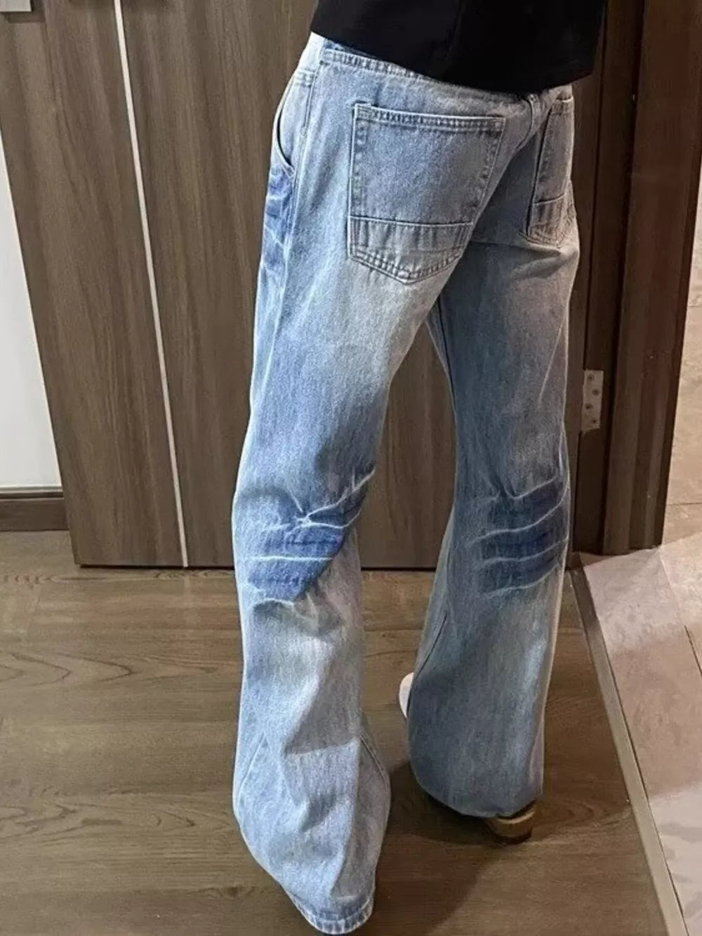 Men's light wash wide-leg jeans with vintage detailing and distressed accents.