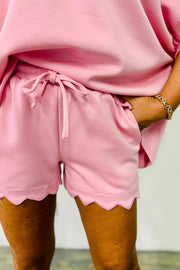 Blush pink lounge shorts with drawstring and scalloped hem.