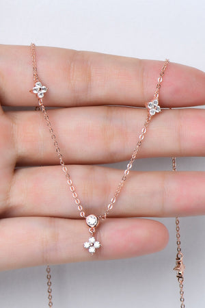 Rose gold necklace with diamond cluster clover charms and a single diamond pendant.