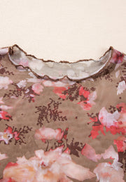 Sheer floral mock neck top with lettuce edge trim.