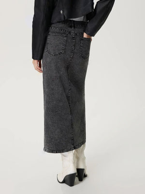 Black denim maxi skirt with high slit and distressed wash, featuring buttoned back pockets.