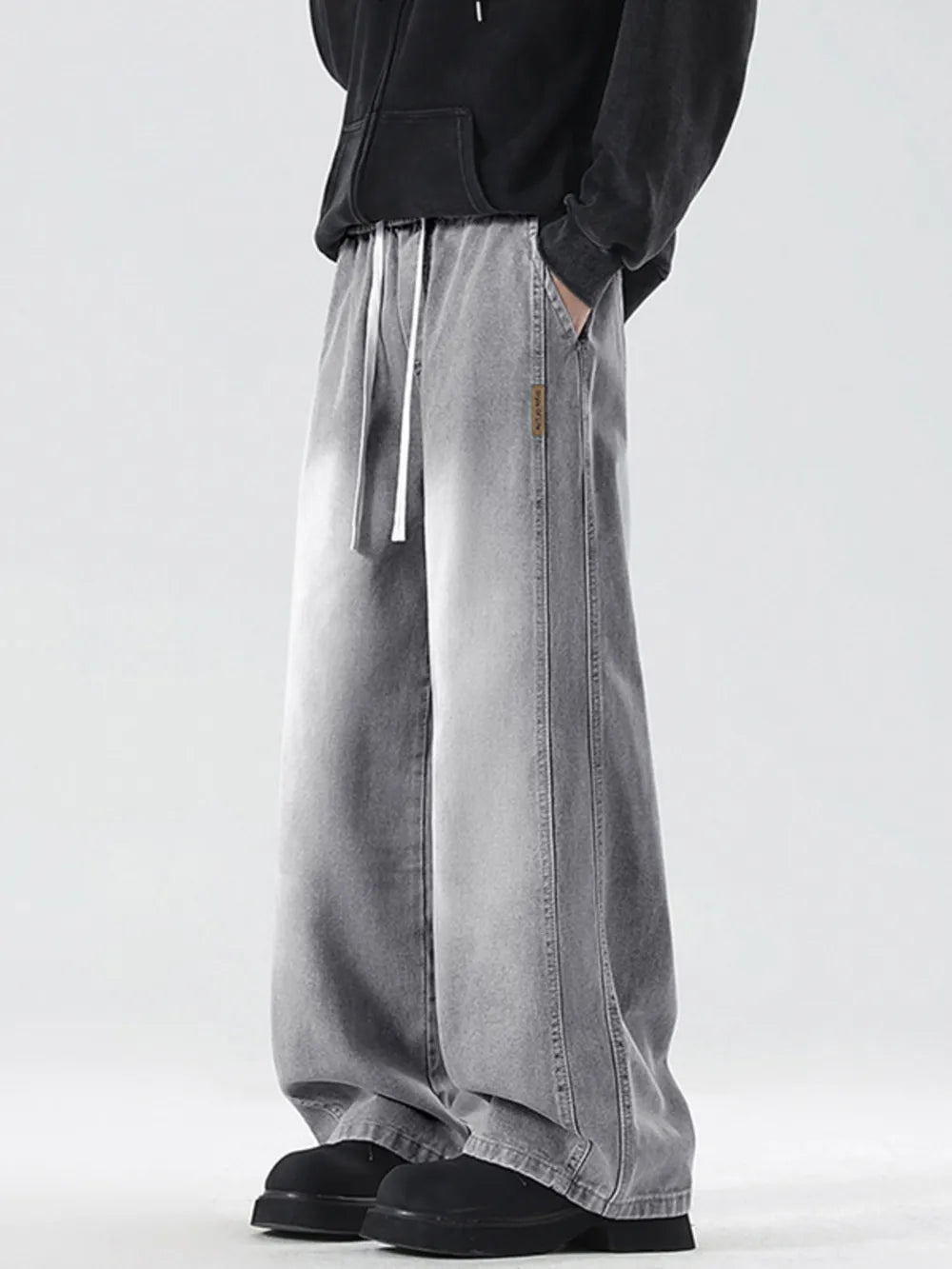 Oversized drawstring washed denim jeans in cement gray with a relaxed fit.