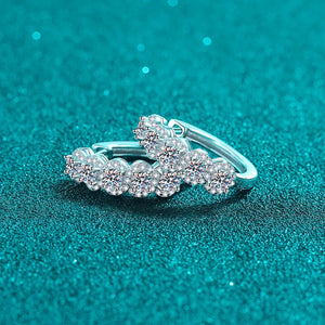 Silver moissanite cluster huggie hoop earrings with sparkling round-cut stones.