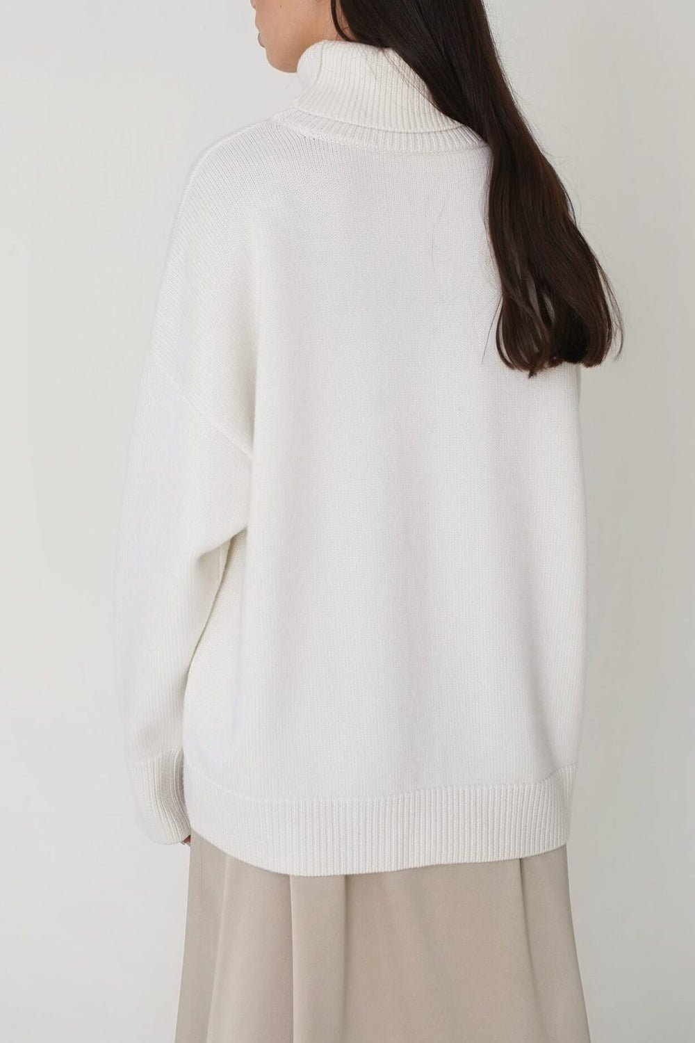 White relaxed roll-neck sweater with a boxy knit and ribbed cuffs and hem.