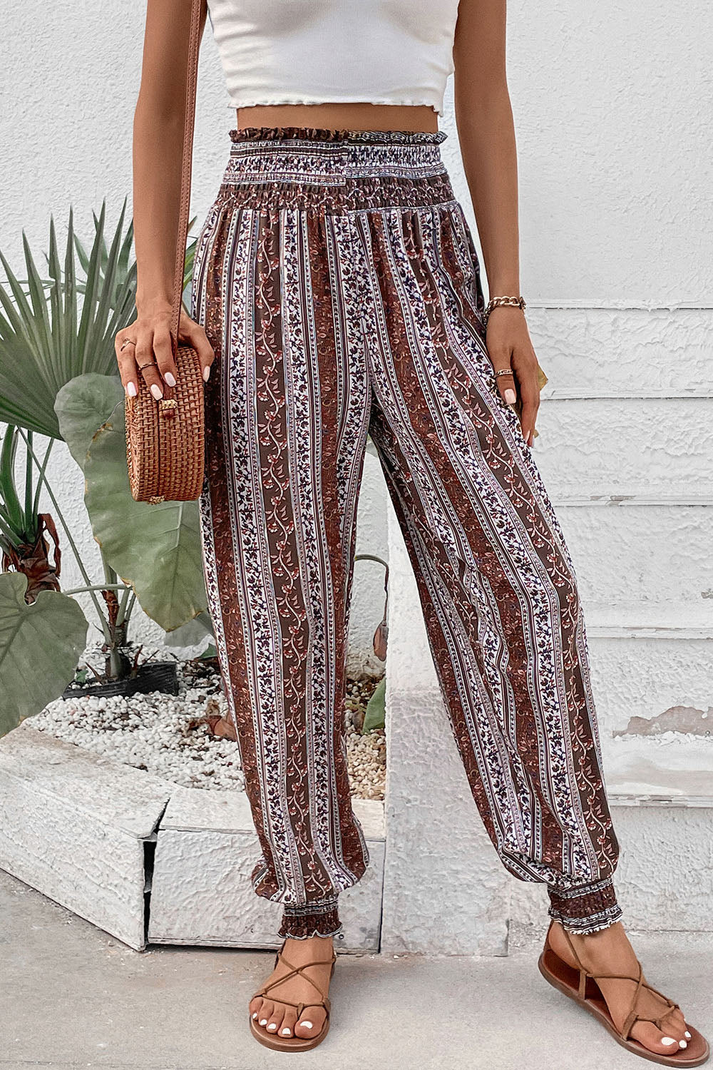 Bohemian smocked waistline trousers in multicolor floral stripe pattern with cinched cuffs.