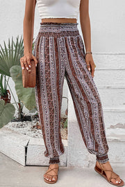 Bohemian smocked waistline trousers in multicolor floral stripe pattern with cinched cuffs.