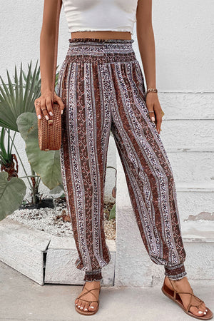 Bohemian smocked waistline trousers in multicolor floral stripe pattern with cinched cuffs.