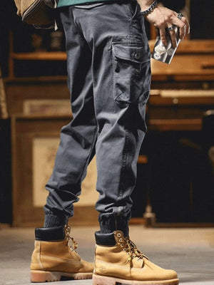 Men's grey cargo joggers with drawstring and elastic cuffs, styled with work boots.