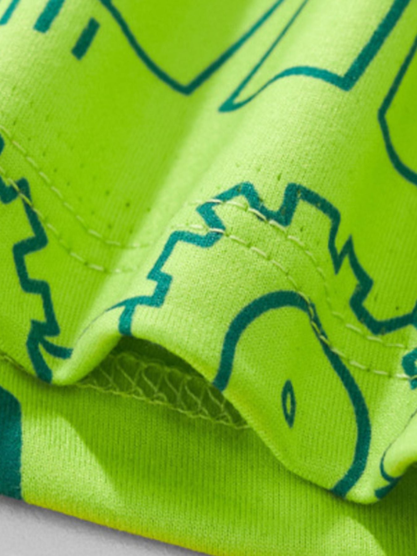 Neon green toddler t-shirt with teal construction vehicle outlines and crew neck.