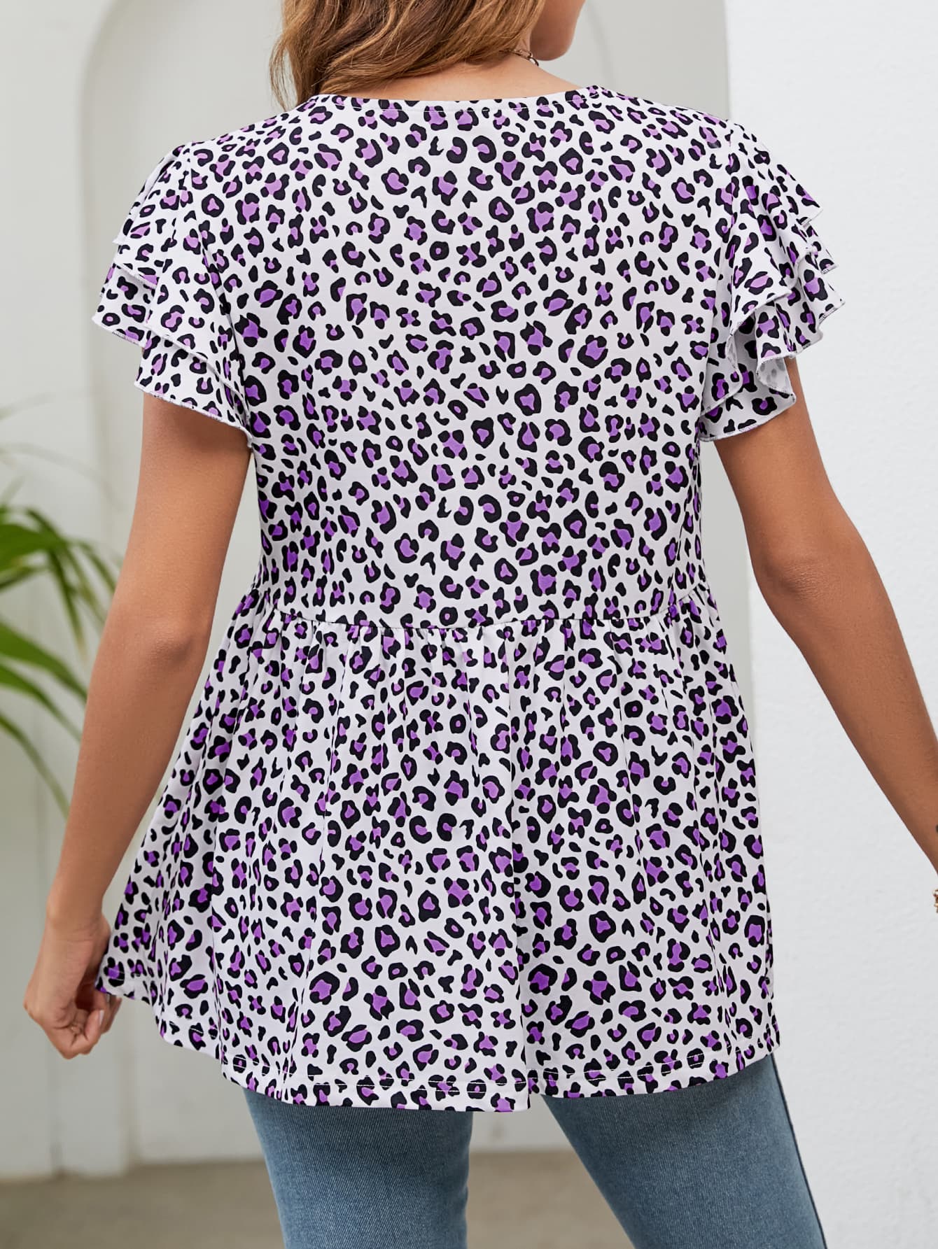 Babydoll blouse with flutter sleeves and purple leopard print.