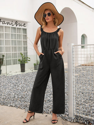 Black textured wide-leg jumpsuit with ruffled straps and a cinched waist.