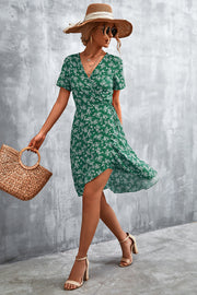 Crimson Floral Wrap Midi Dress in Light Green with white floral print, V-neck, short sleeves, and asymmetrical hem.