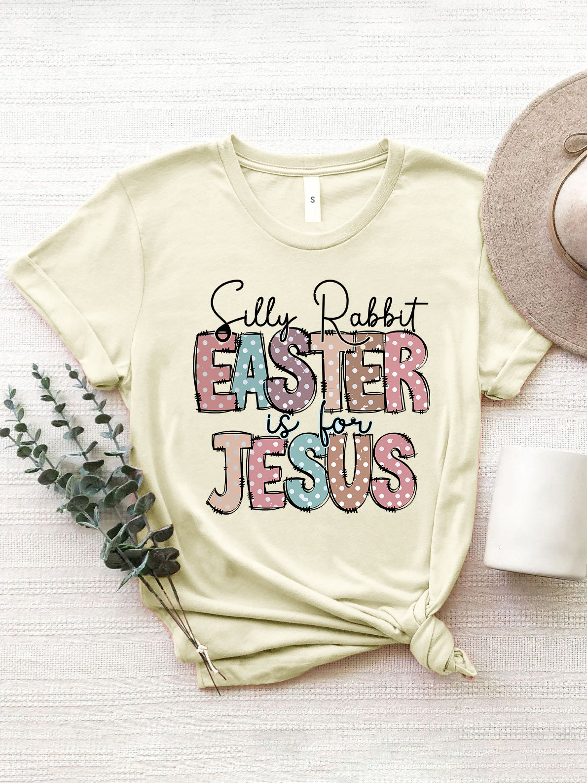Cream Easter graphic tee with pastel polka dot text that reads "Silly Rabbit EASTER is for JESUS.
