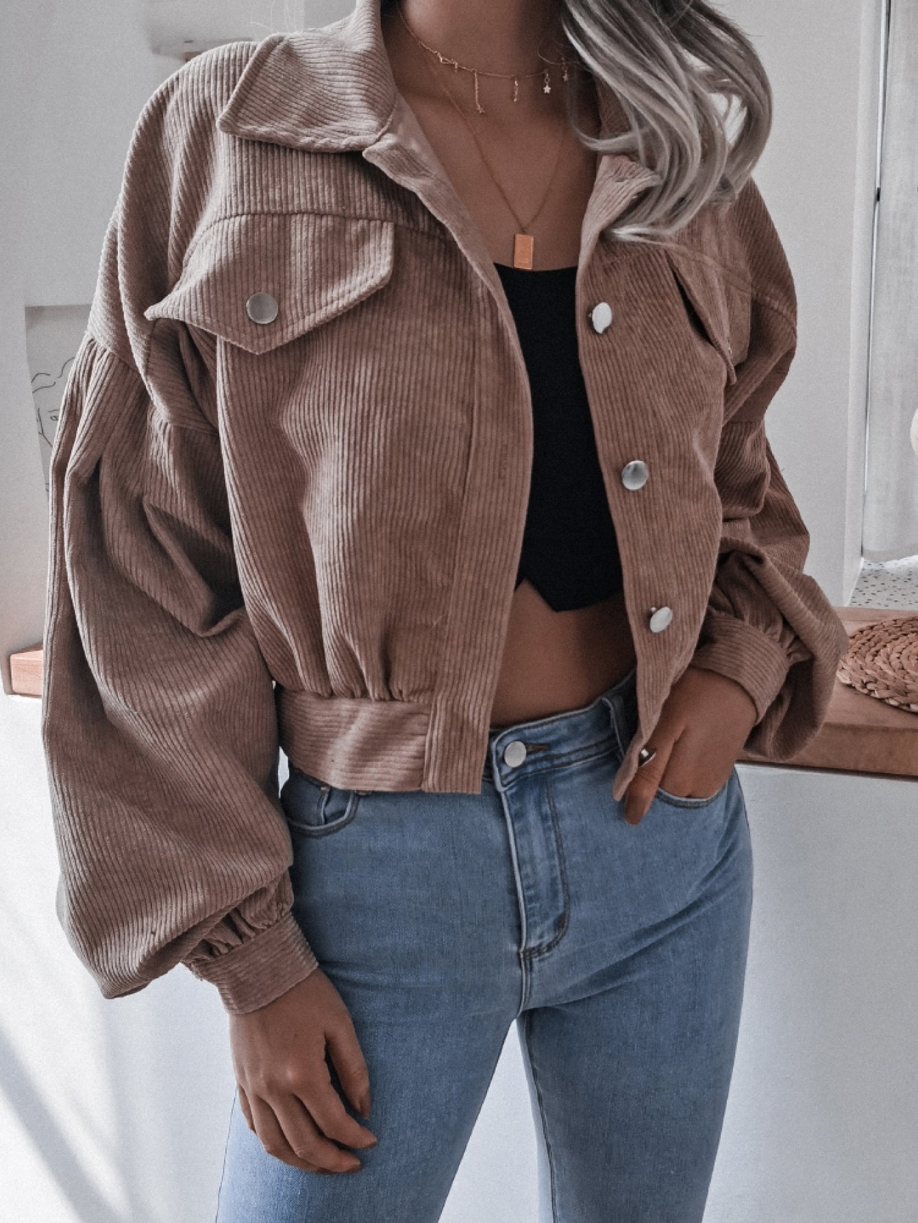Brown corduroy cropped jacket with balloon sleeves and button-up front.