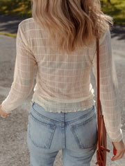 Sheer plaid long-sleeve top in beige with lettuce hem detail, styled with denim jeans.